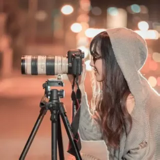 Une photographe s'apprêtant à prendre une photo avec un appareil sur trépier